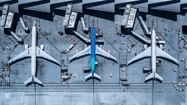 Airplanes parked at airport gates during weather delays.