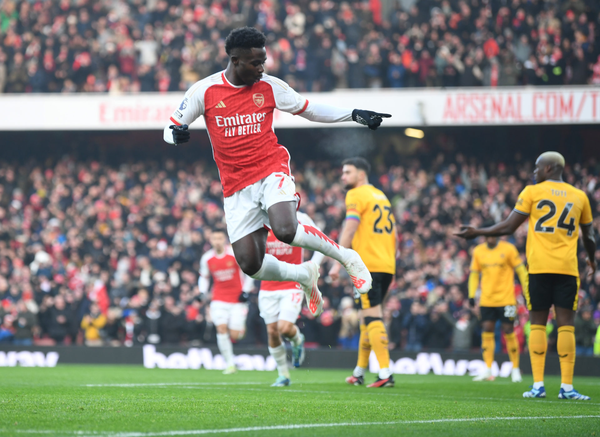 Arsenal winger Bukayo Saka (7) celebrates a goal at the Emirates Stadium in a red Arsenal home kit.