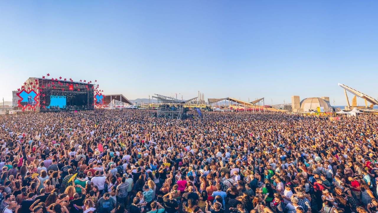 A vast crowd at Primavera Sound Barcelona in the golden light of evening, with a main stage to the left