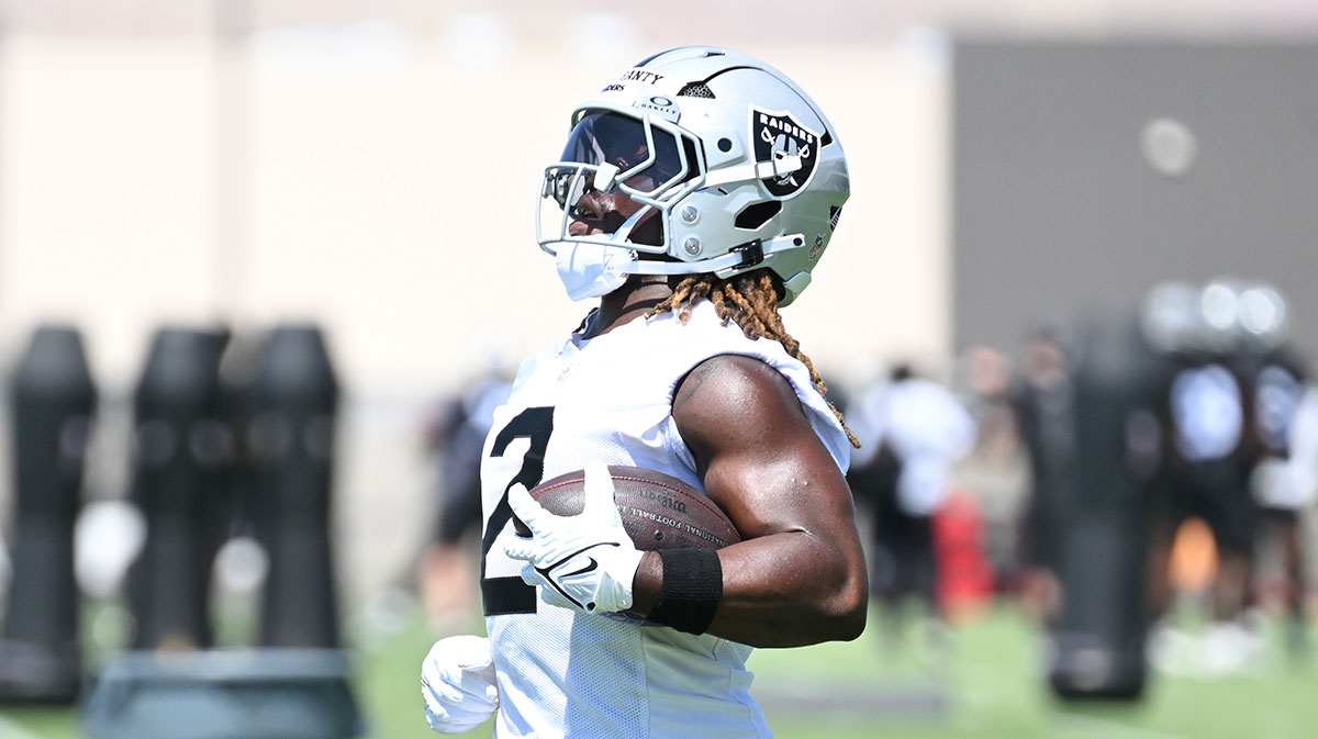 Ashton Jeanty holding a football at Raiders practice