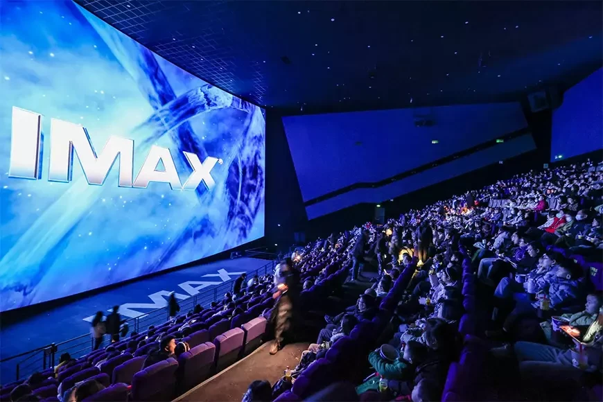 A packed IMAX auditorium with the audience facing a giant IMAX screen