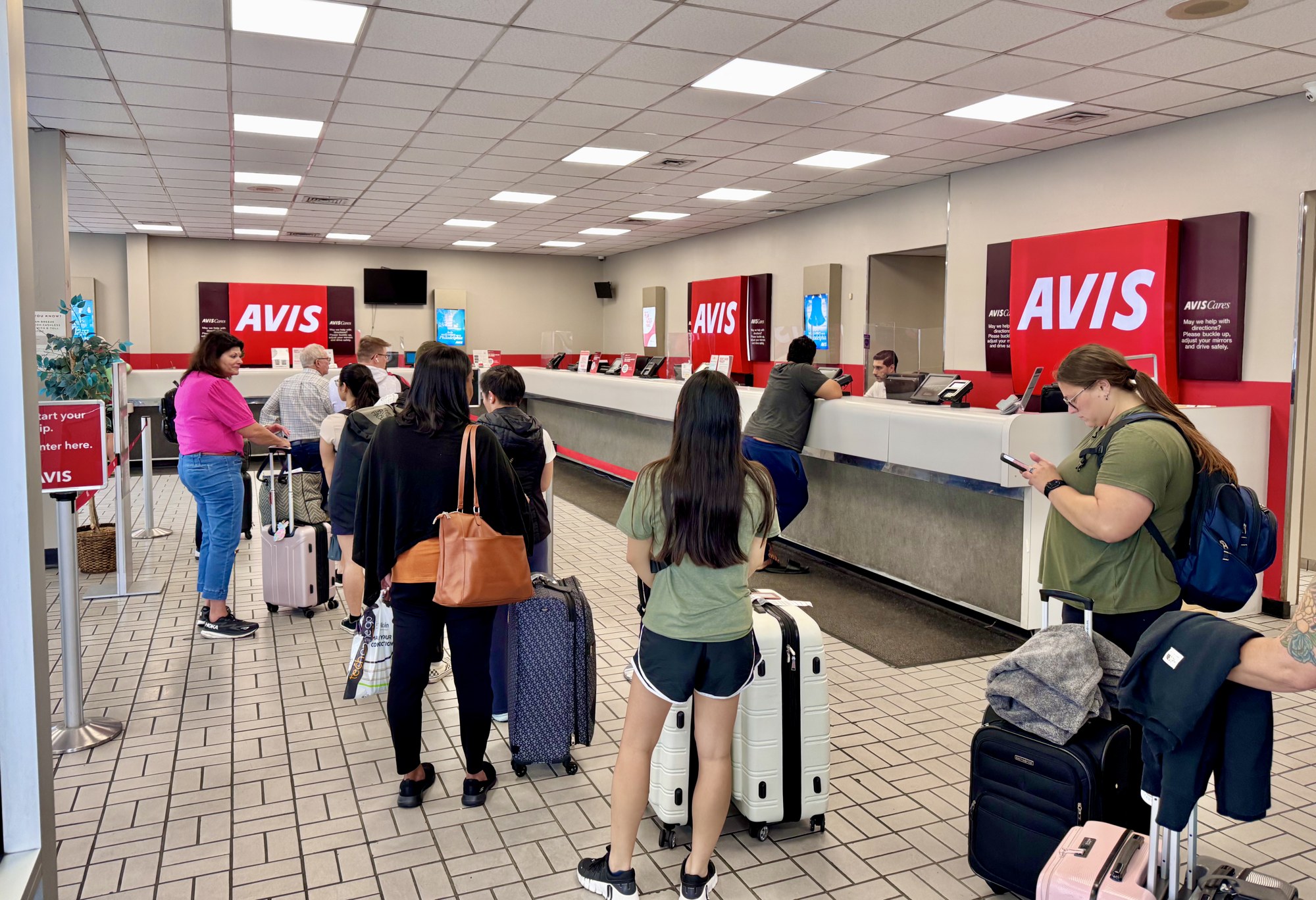 Travellers with luggage at an Avis car rental counter at Philadelphia International Airport (file photo)