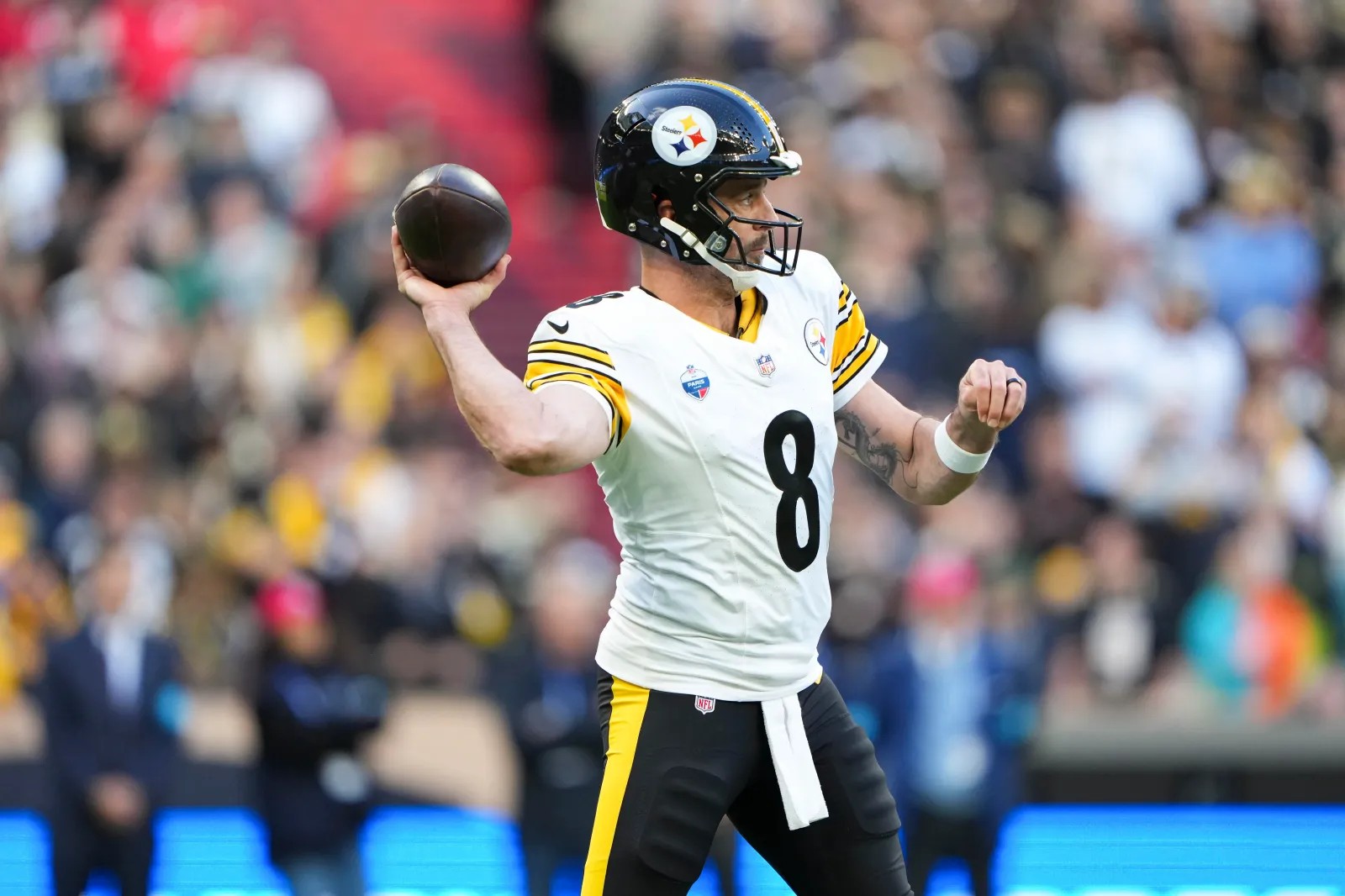 Aaron Rodgers of the Pittsburgh Steelers, wearing the white away uniform with the NFL Paris game patch on his chest, in his throwing motion at Stade de France during the Steelers' game against the New Orleans Saints in Paris on October 25, 2026