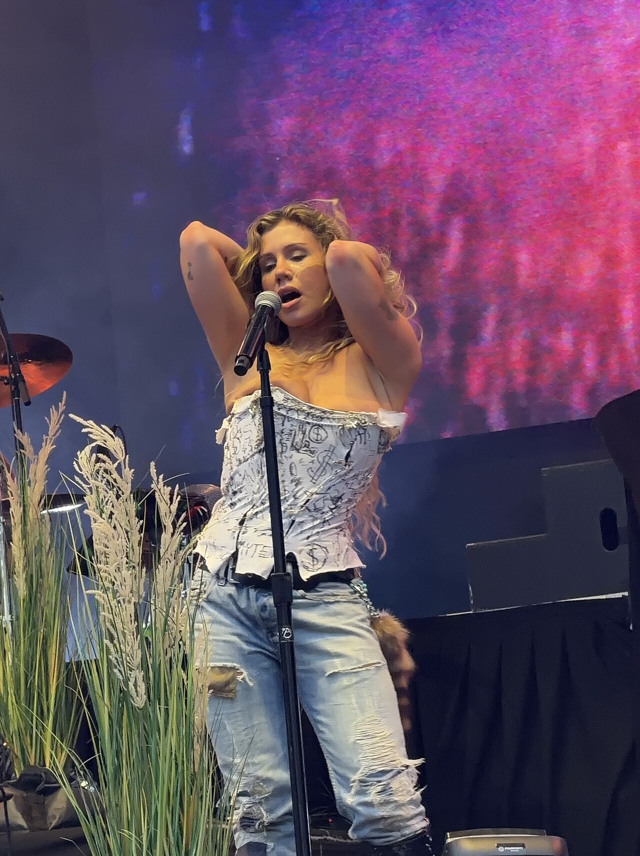 Slayyyter performing on stage during her 2026 tour, bathed in pink and blue stage light