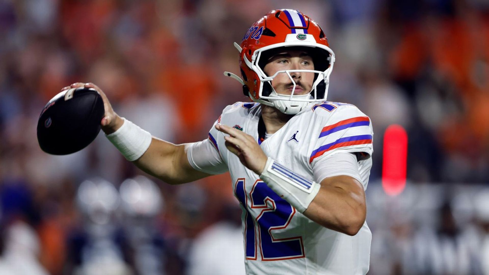 Florida quarterback Aaron Philo, wearing No. 12 in Florida's white away uniform and orange helmet, throwing a pass during a 2026 game