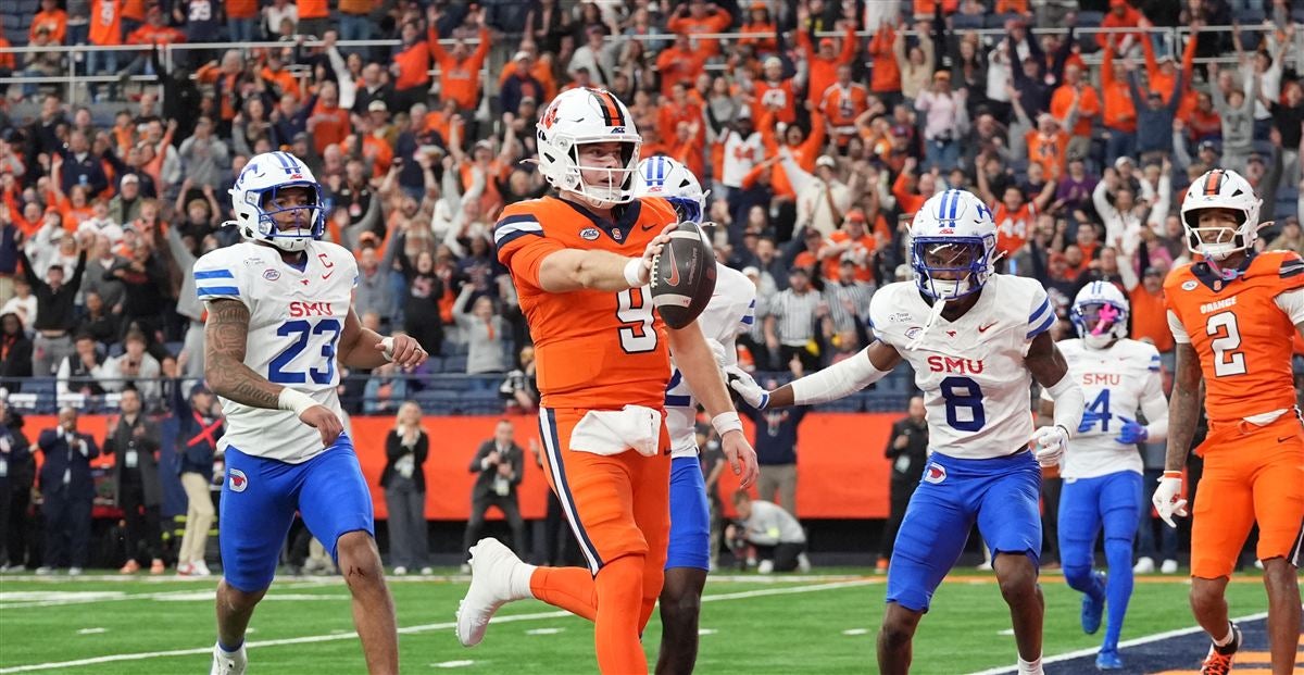 Syracuse quarterback Steve Angeli runs into the open field as SMU defenders give chase and the Dome crowd rises