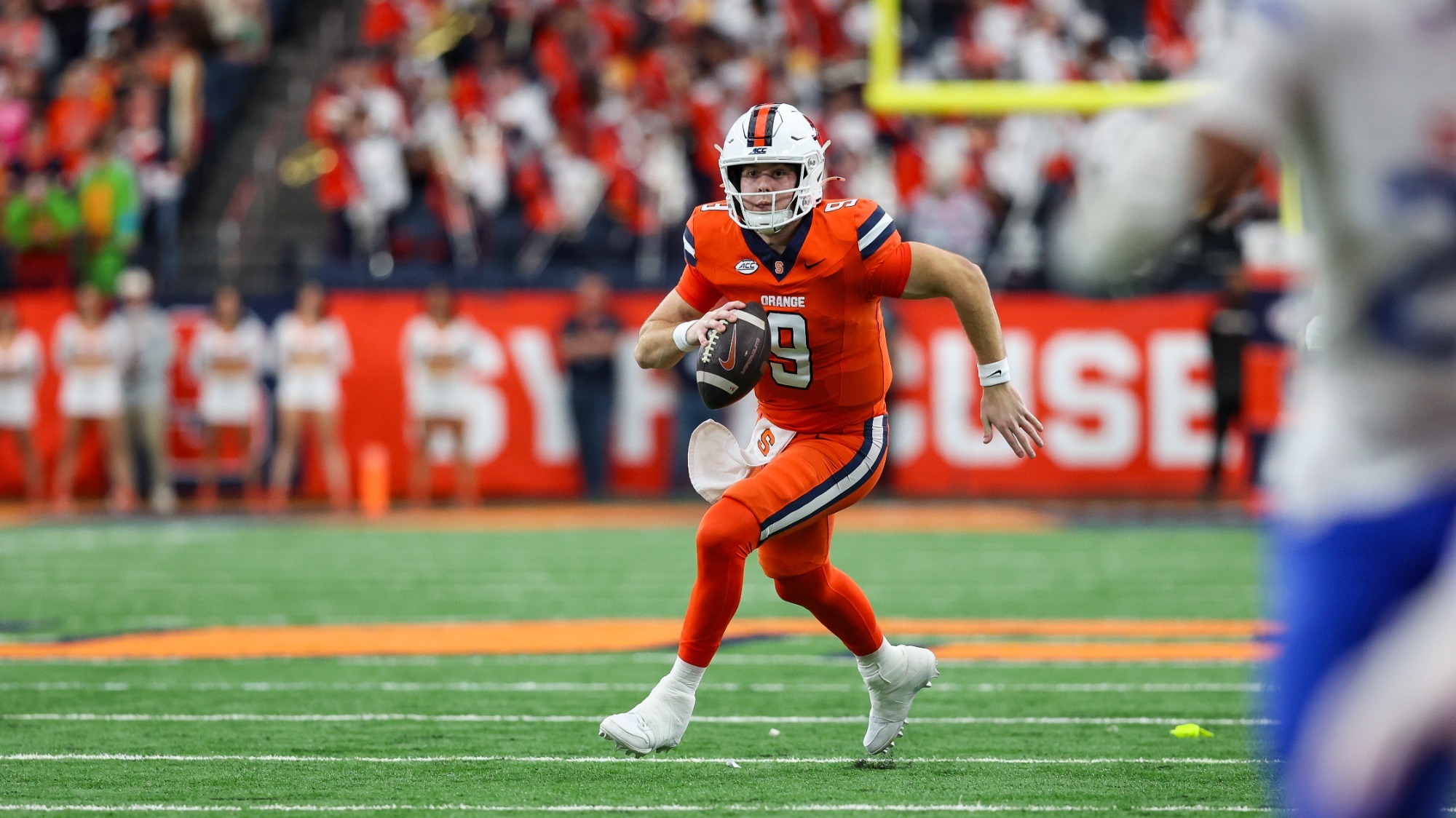 Syracuse quarterback Steve Angeli scrambles with the ball against SMU at the JMA Wireless Dome — he threw the winning touchdown with 17 seconds left in a 30–27 upset