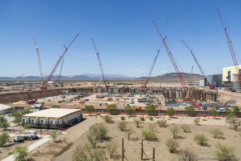 Construction at TSMC's Arizona semiconductor campus near Phoenix, with cranes over the fab site.