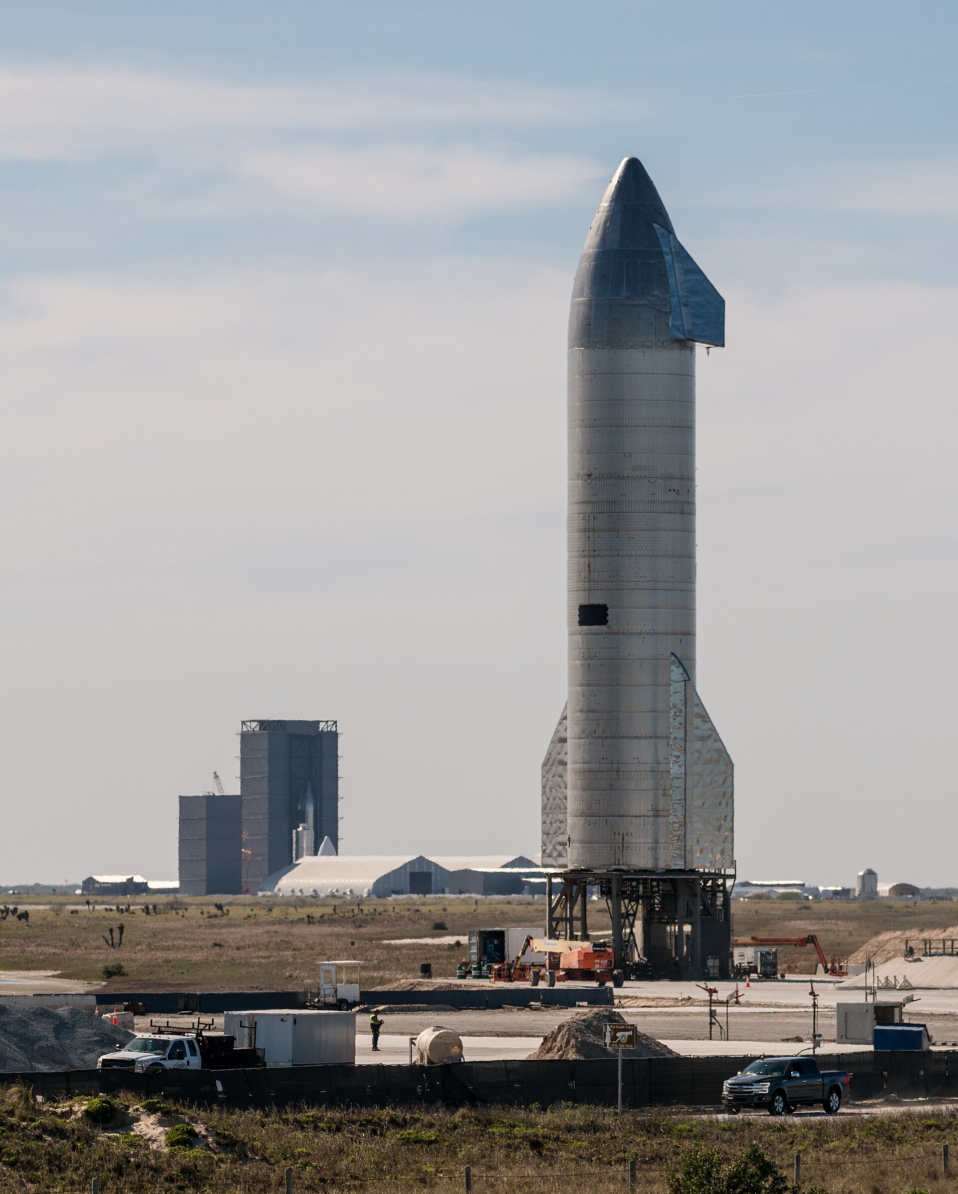 A SpaceX rocket on the launch pad under a bright daytime sky