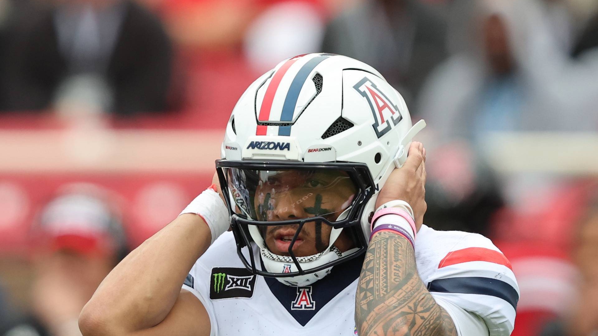 Arizona quarterback Noah Fifita listens for the play call with his hands on his helmet at Galaxy Stadium