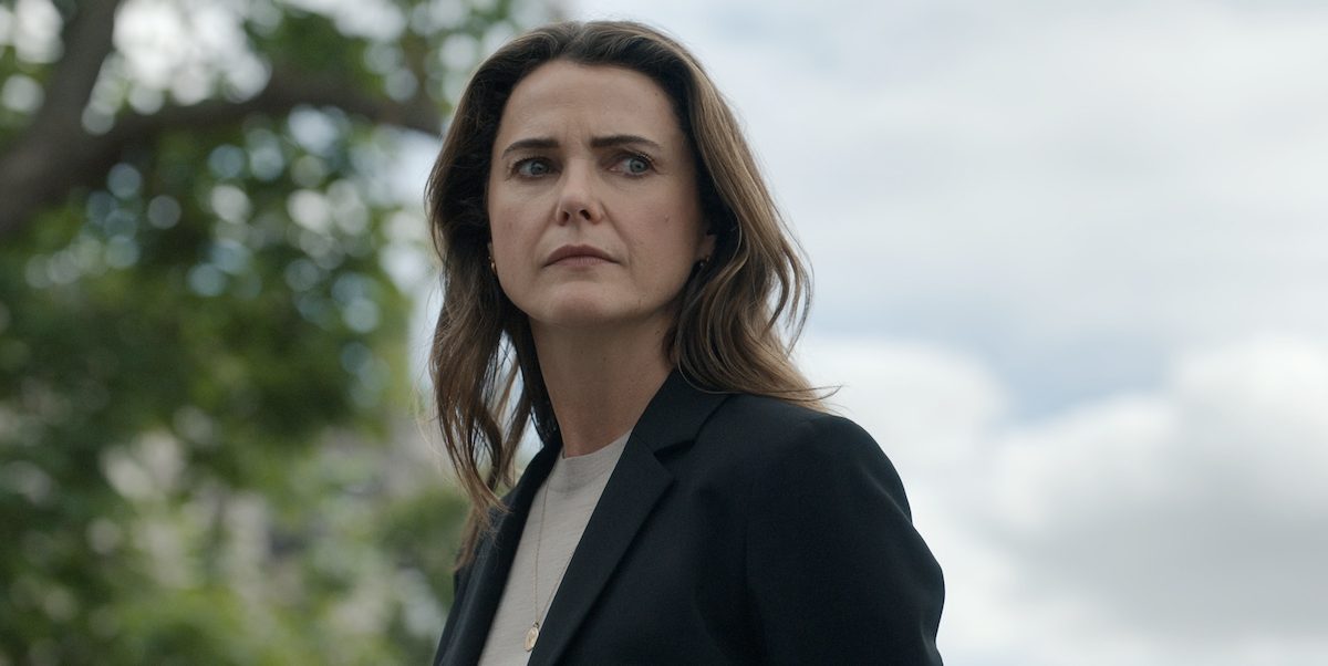 Keri Russell as U.S. Ambassador Kate Wyler in Netflix's The Diplomat, standing outdoors in a dark blazer with a tense expression