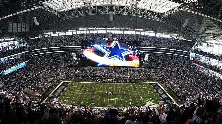 AT&T Stadium in Arlington, Texas, lit up at night.