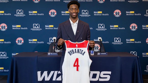 AJ Dybantsa holding a Washington Wizards jersey at his introductory press conference.