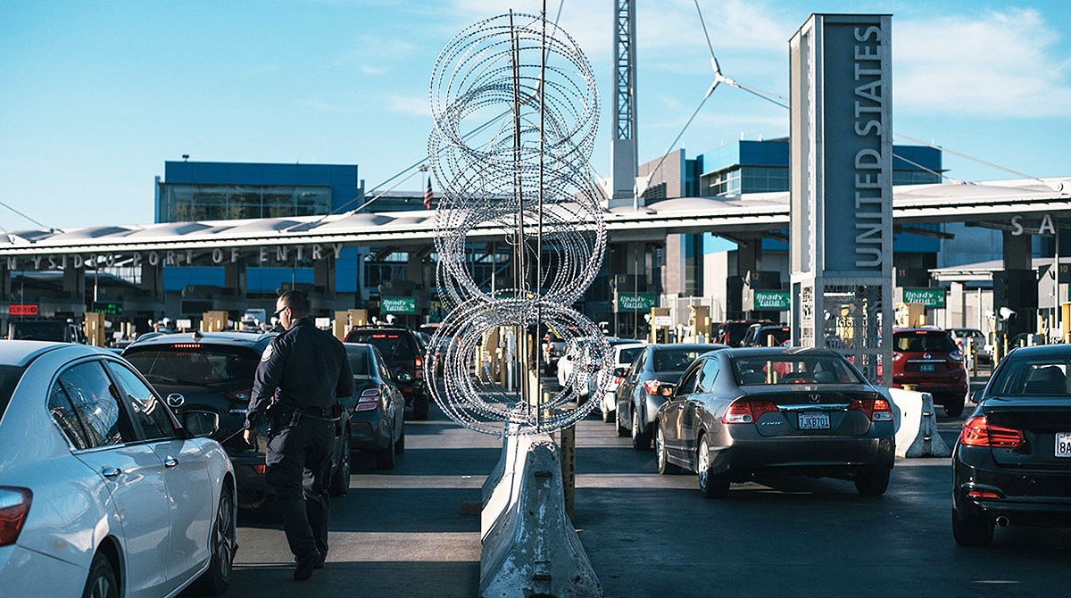 A U.S. port of entry with a Customs and Border Protection officer and inspection lanes