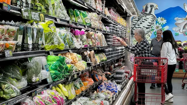Shoppers browse produce at a grocery store