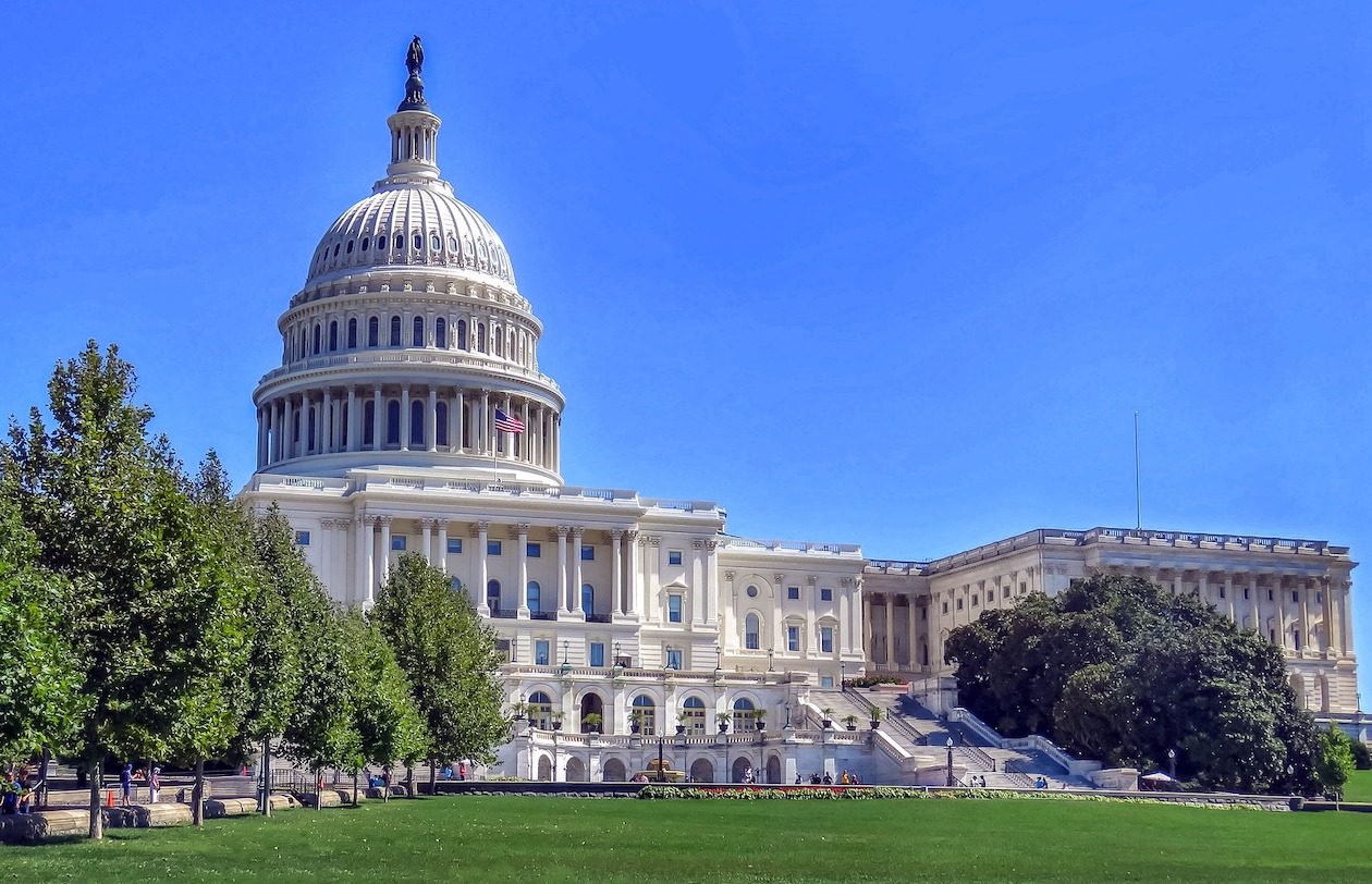 The U.S. Capitol building against a bright blue sky