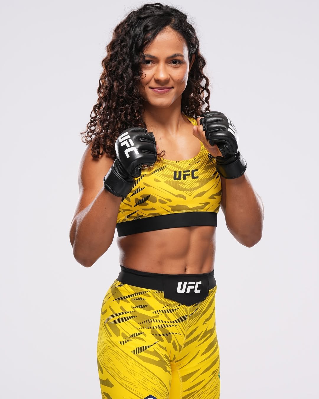 Natália Silva in a UFC portrait, wearing a yellow fight kit