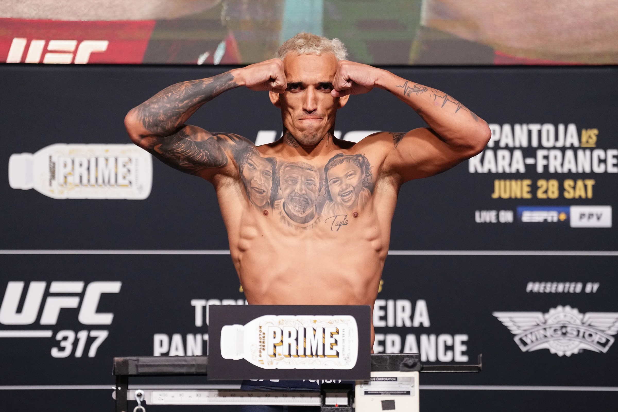 Charles Oliveira poses on the scales at a UFC weigh-in — file photo