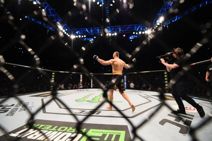 A UFC fighter celebrates a win inside the octagon