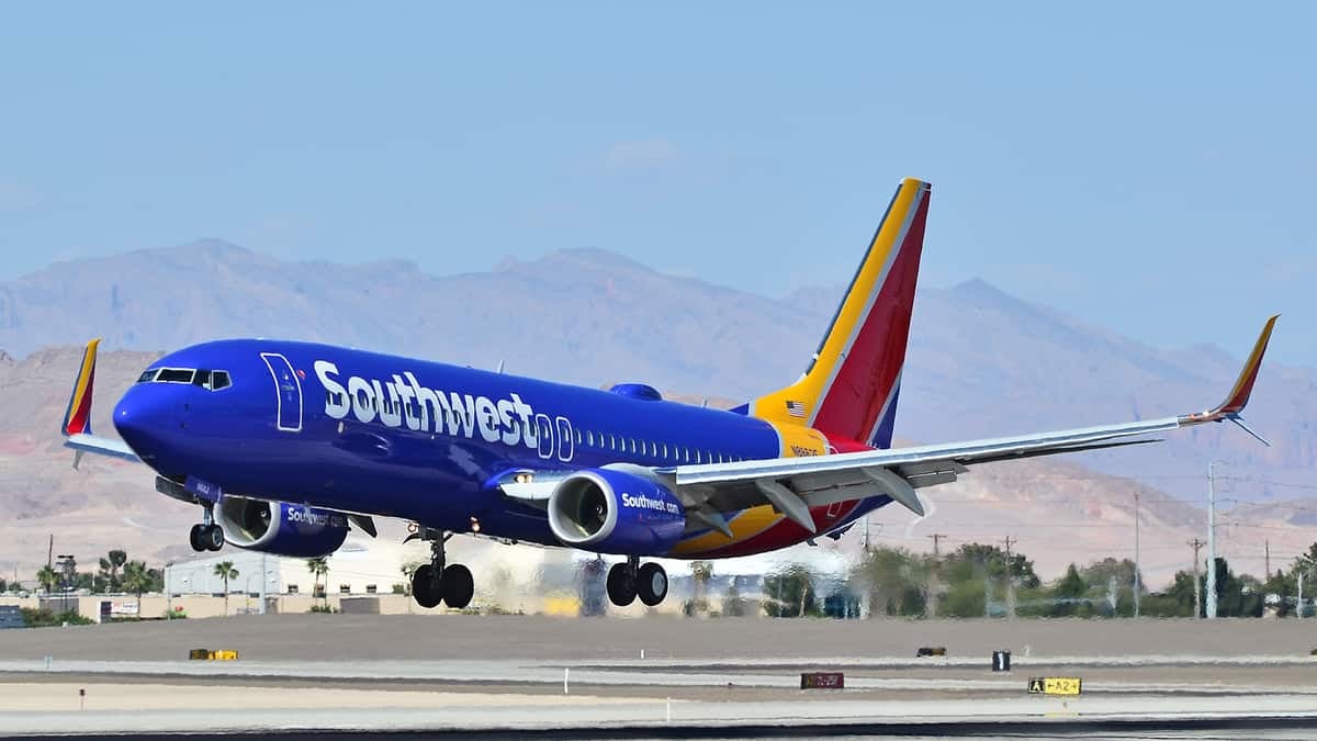 A Southwest Airlines jet landing in Las Vegas with the desert mountains behind it