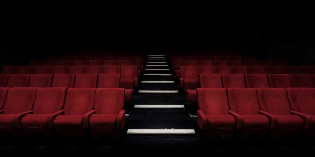 Rows of empty red seats in a darkened movie theater