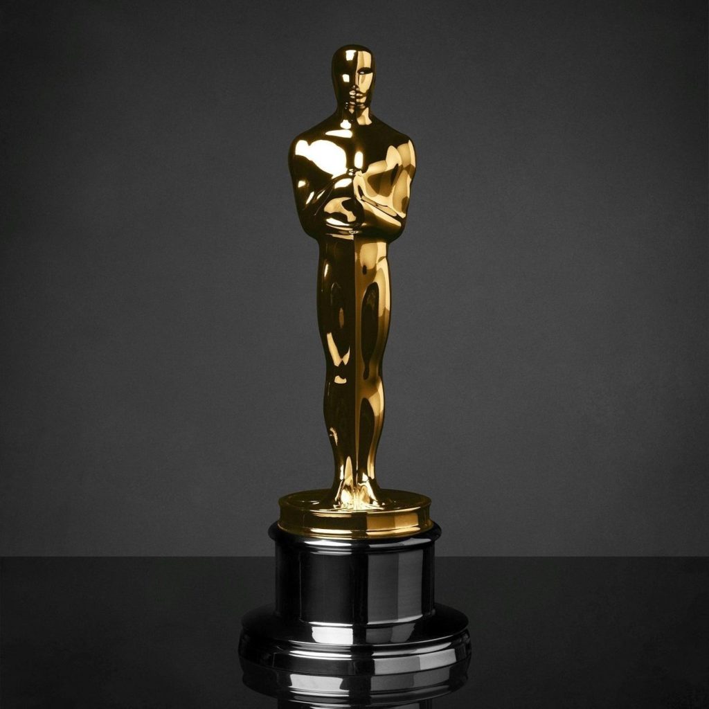 A gold Oscar statuette against a dark background