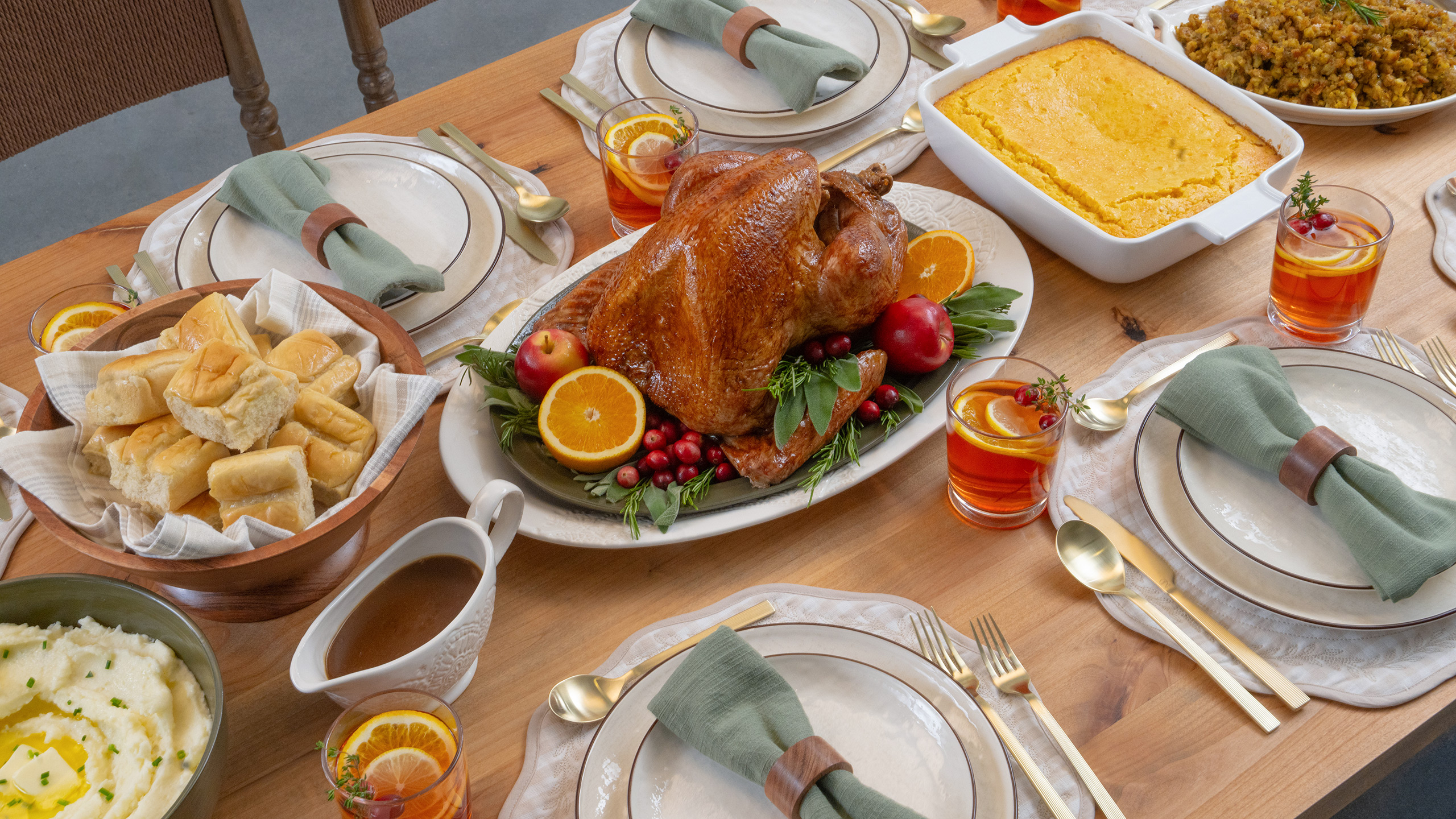 The Walmart holiday basket cooked and served: a roast turkey on a platter surrounded by dinner rolls, mashed potatoes, gravy, corn casserole and stuffing.