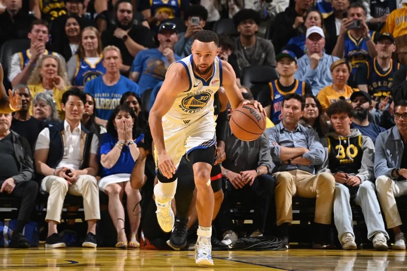 Steph Curry driving to the basket in a Golden State Warriors uniform
