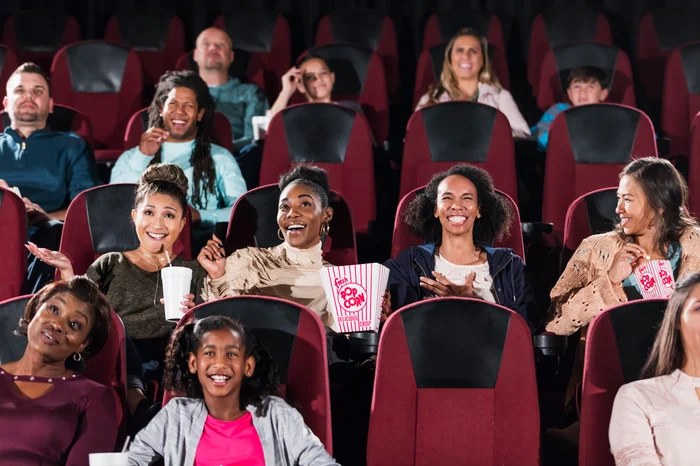 A crowded movie theater audience with popcorn