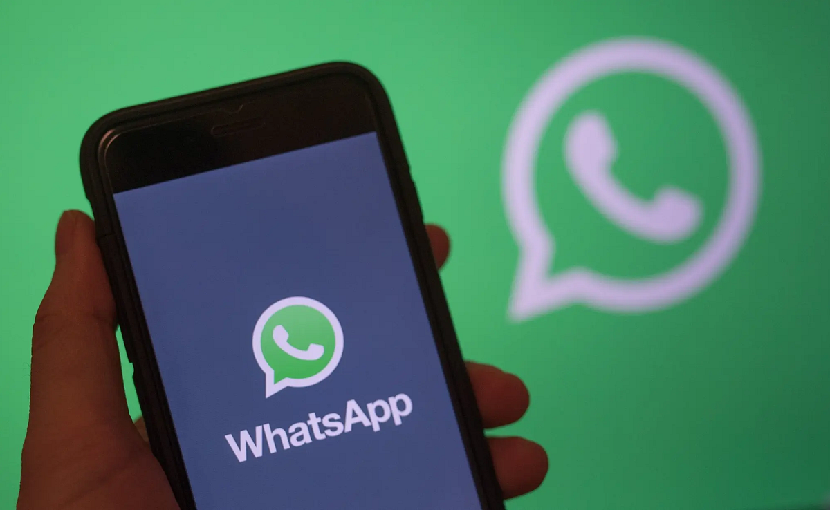 The WhatsApp app icon and chat interface on a smartphone