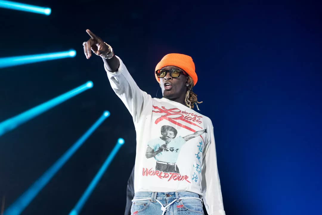 Young Thug performing on stage in an orange beanie