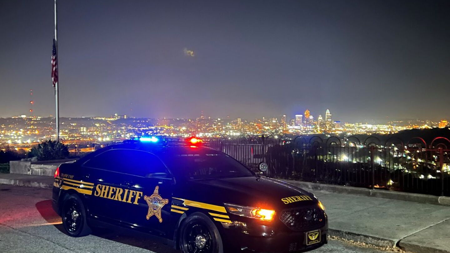 A sheriff's cruiser with emergency lights on at night