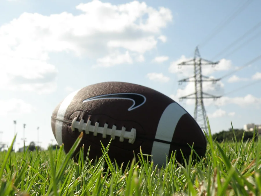 Football spiraling through night air