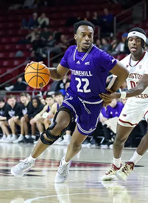 Stonehill Skyhawks guard drives against Boston University